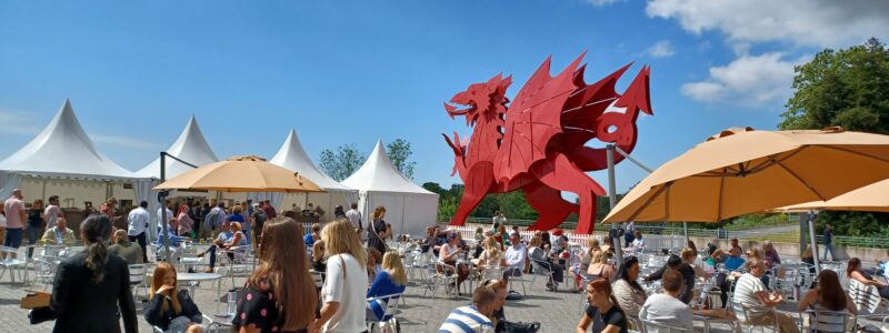 A crowd gathered near a statue of a Welsh dragon in Newport, Wales, Civil Service Live 2024.